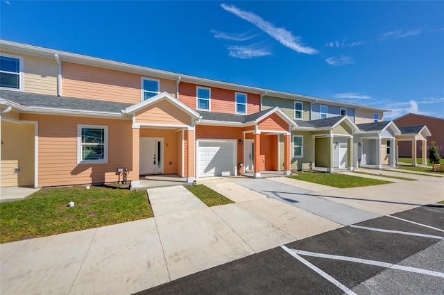 townhome / multi-family property with a garage and roof with shingles