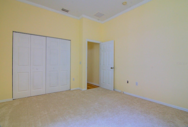 unfurnished bedroom featuring ornamental molding, a closet, and light colored carpet