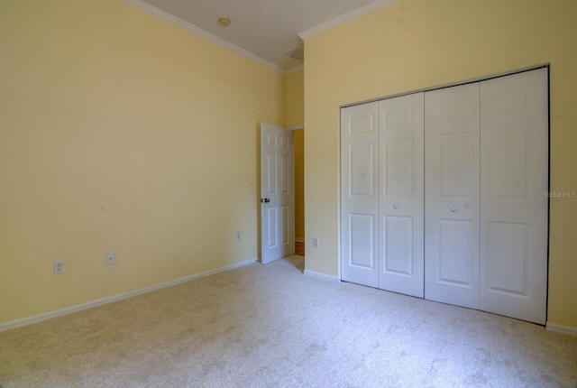 unfurnished bedroom with a closet, light colored carpet, and crown molding