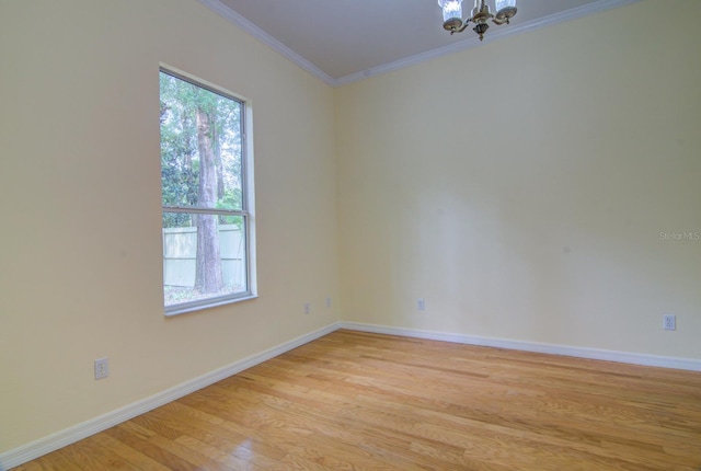 unfurnished room featuring light wood-type flooring, a chandelier, and ornamental molding