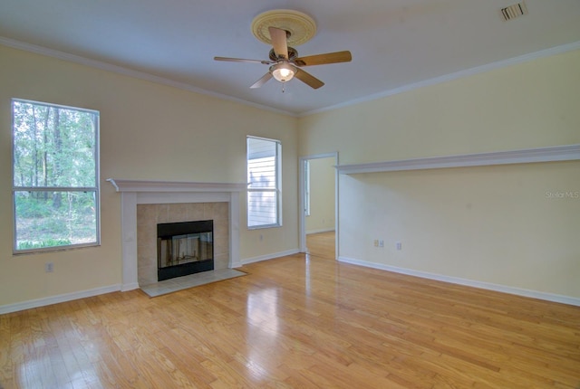 unfurnished living room with ceiling fan, a fireplace, crown molding, and light hardwood / wood-style floors