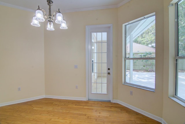 doorway to outside featuring light hardwood / wood-style flooring, a chandelier, and ornamental molding