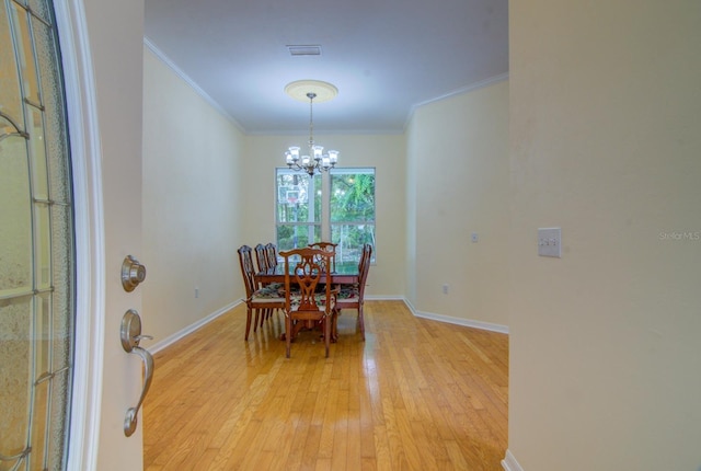 dining room featuring ornamental molding, a chandelier, and light hardwood / wood-style floors