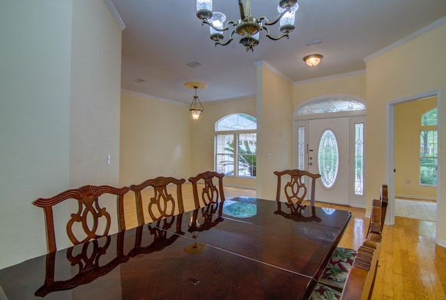 dining space featuring a notable chandelier, light wood-type flooring, and ornamental molding