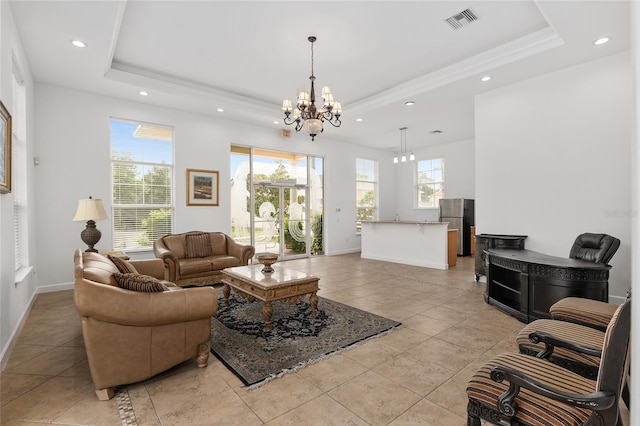 tiled living room with a tray ceiling and an inviting chandelier