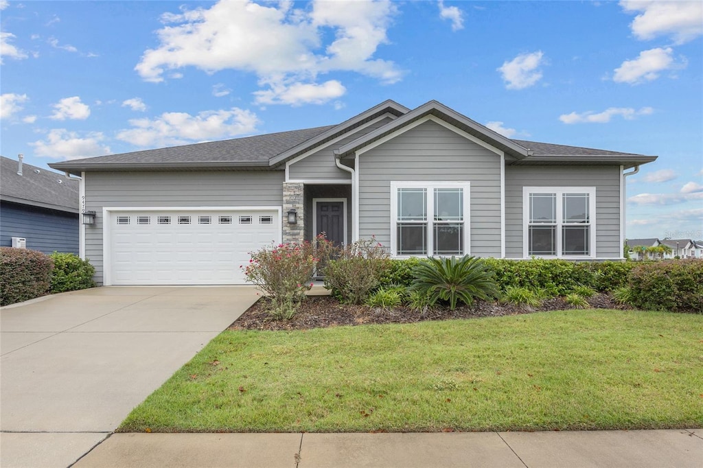 ranch-style home featuring a front lawn and a garage