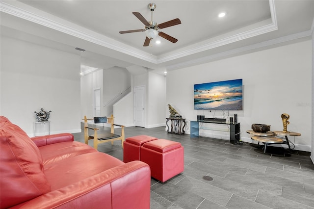 living room with ornamental molding, ceiling fan, and a raised ceiling