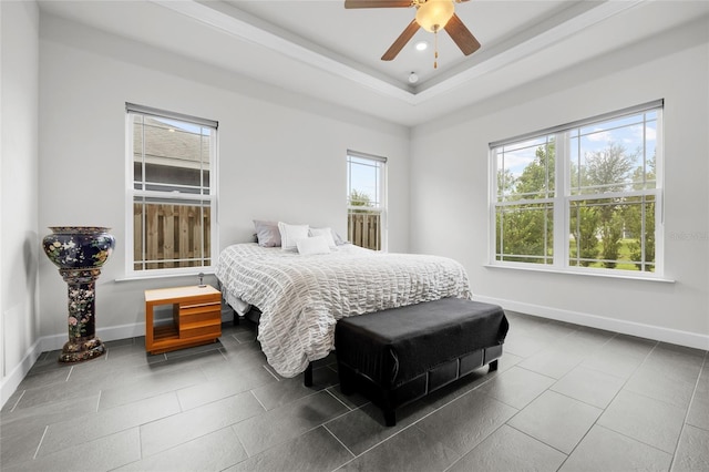 tiled bedroom featuring a raised ceiling and ceiling fan