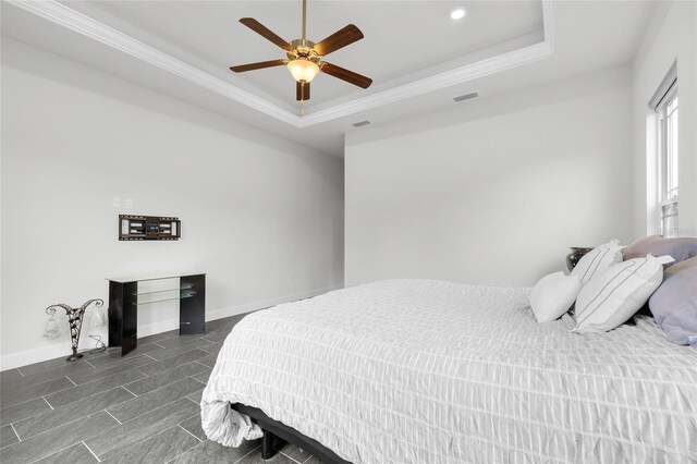 bedroom featuring crown molding, a tray ceiling, and ceiling fan