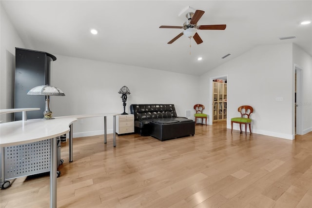 living area featuring light hardwood / wood-style flooring, lofted ceiling, and ceiling fan