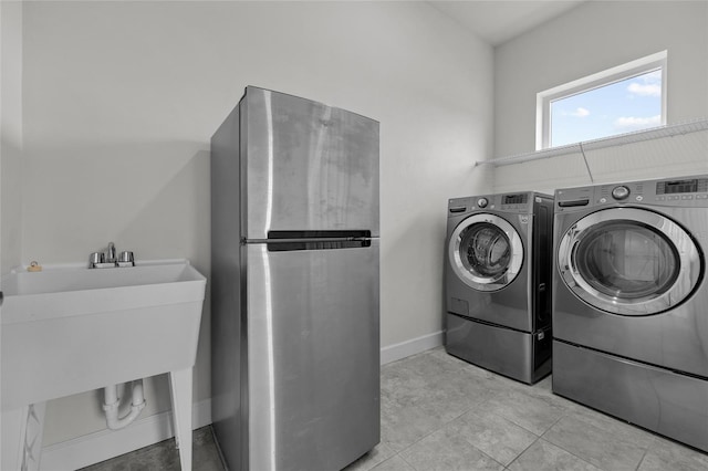 washroom with washing machine and clothes dryer and light tile patterned floors