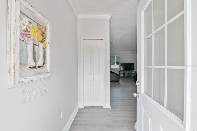 hall with light hardwood / wood-style flooring and ornamental molding