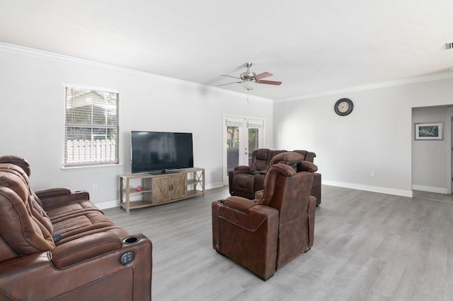 living room with ornamental molding, light hardwood / wood-style floors, ceiling fan, and french doors