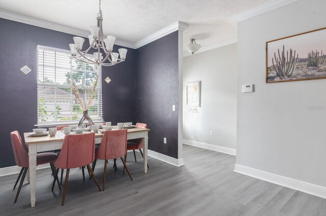 dining space featuring ornamental molding, wood-type flooring, and a chandelier