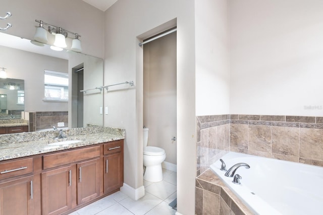 bathroom with tile patterned floors, tiled bath, vanity, and toilet