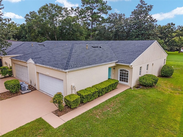 single story home with central air condition unit, a garage, and a front lawn