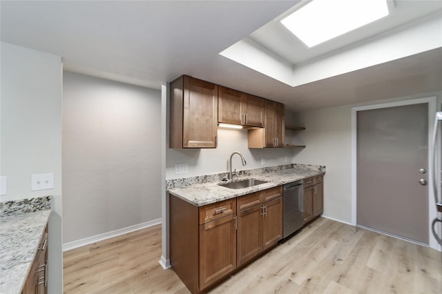 kitchen with dishwasher, light wood-type flooring, sink, and light stone countertops