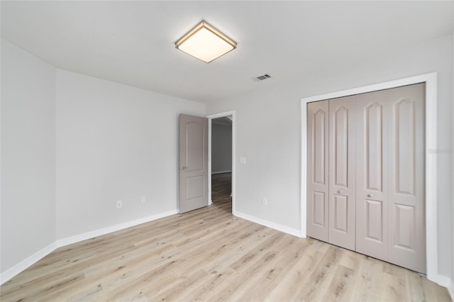 unfurnished bedroom featuring a closet and light hardwood / wood-style flooring