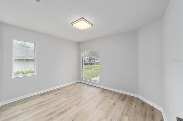 spare room with plenty of natural light and light hardwood / wood-style flooring