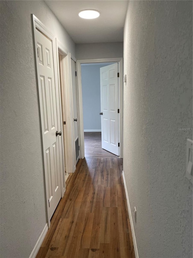 hallway with dark wood-type flooring