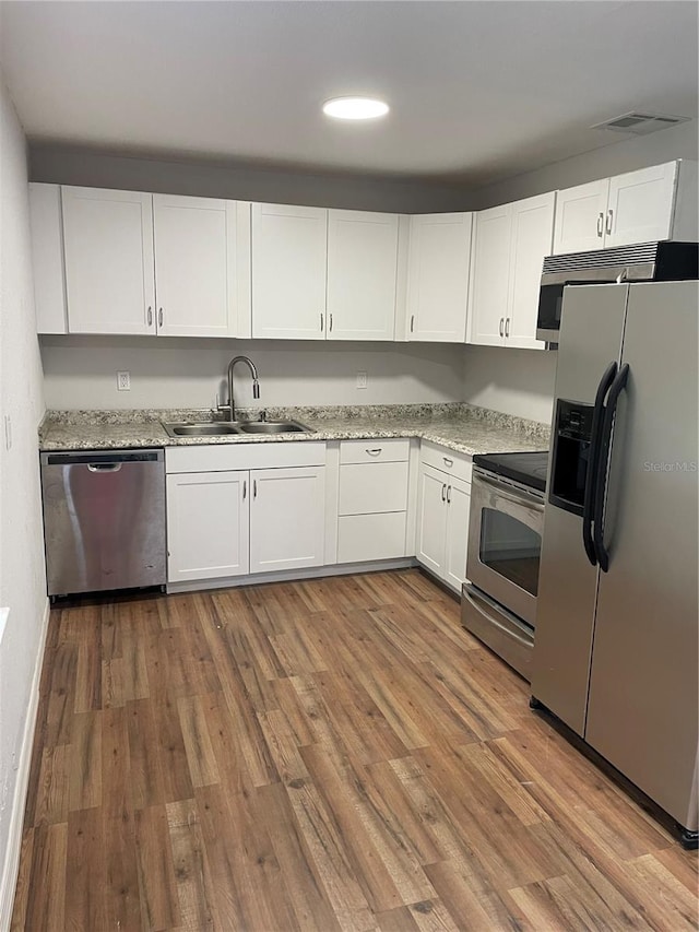 kitchen featuring white cabinets, sink, hardwood / wood-style flooring, and stainless steel appliances