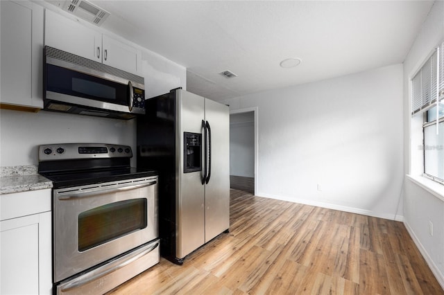 kitchen with white cabinetry, appliances with stainless steel finishes, and light hardwood / wood-style floors