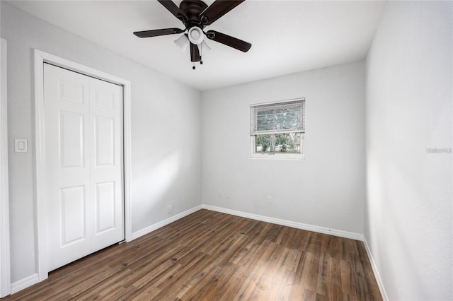 unfurnished bedroom with ceiling fan, a closet, and dark hardwood / wood-style flooring