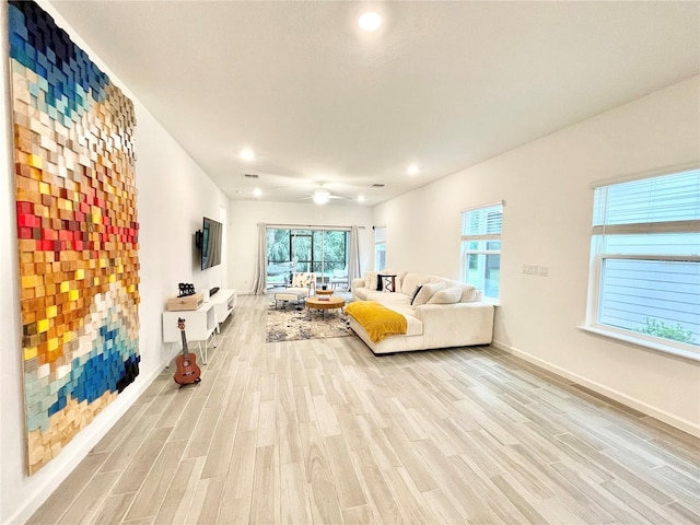 living room featuring a wealth of natural light, light hardwood / wood-style floors, and ceiling fan