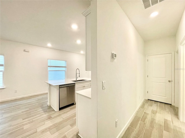 kitchen featuring white cabinetry, dishwasher, sink, kitchen peninsula, and light wood-type flooring