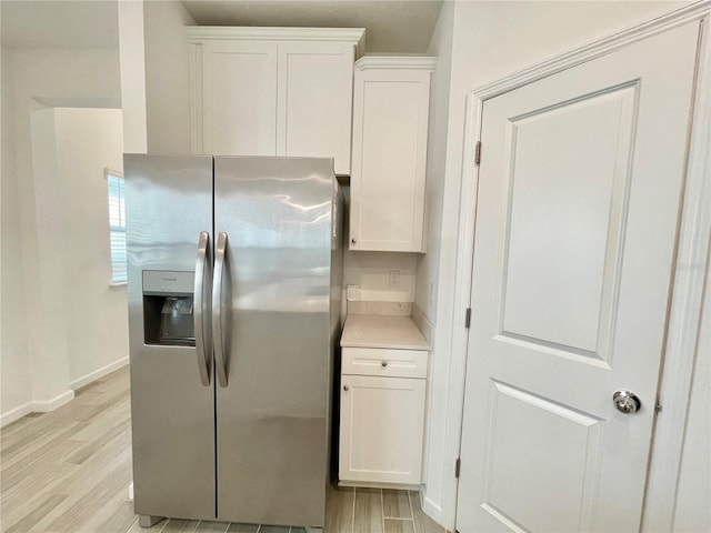 kitchen featuring white cabinetry, light hardwood / wood-style flooring, and stainless steel fridge with ice dispenser