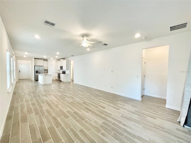 unfurnished living room featuring light hardwood / wood-style flooring and ceiling fan