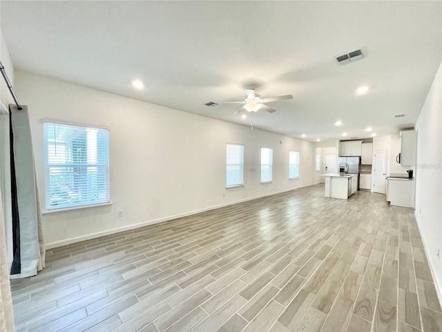 unfurnished living room featuring ceiling fan and light hardwood / wood-style floors