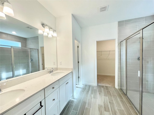 bathroom with a shower with door and vanity