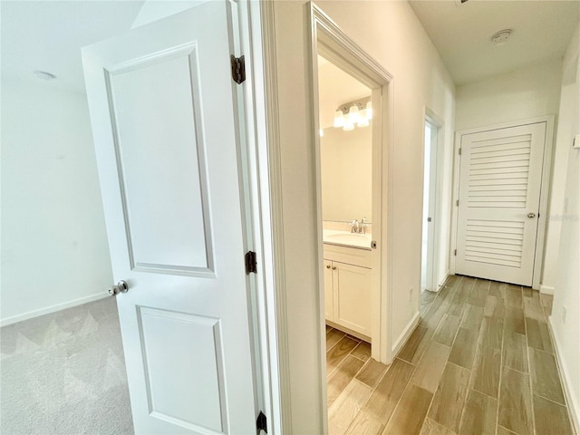 corridor featuring sink and light wood-type flooring