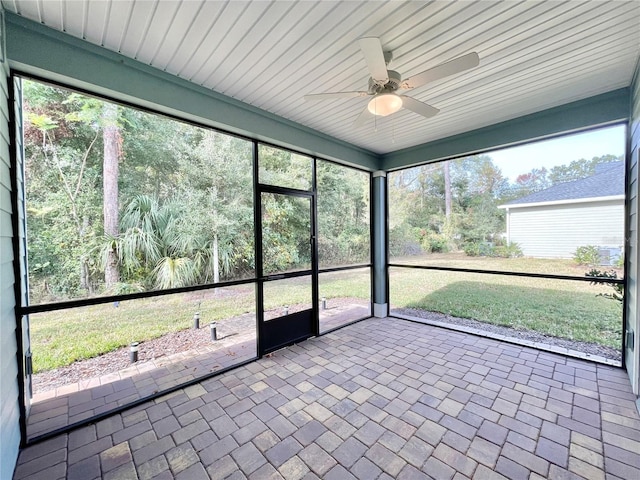 unfurnished sunroom featuring ceiling fan