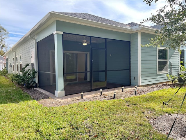 rear view of house with a lawn and a sunroom