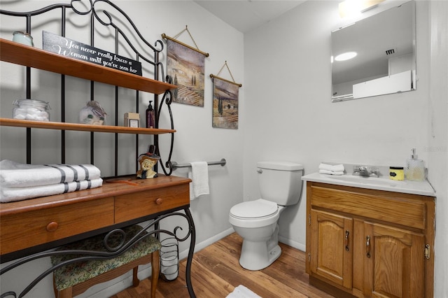 bathroom featuring vanity, wood-type flooring, and toilet