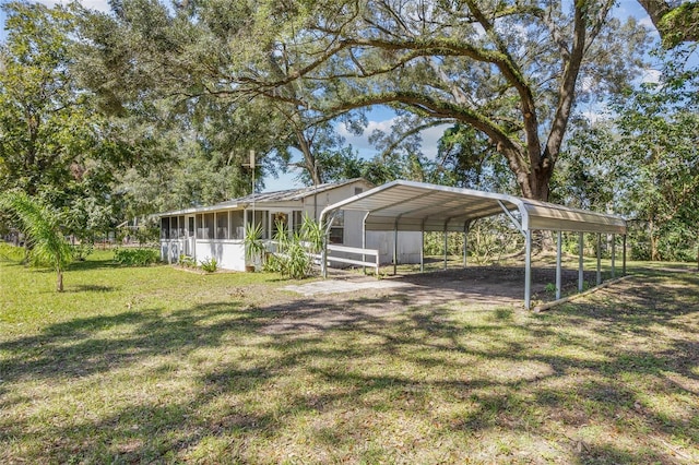 view of yard featuring a carport and a sunroom