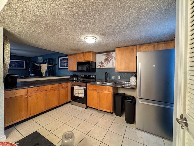 kitchen with light tile patterned floors, a textured ceiling, sink, and black appliances