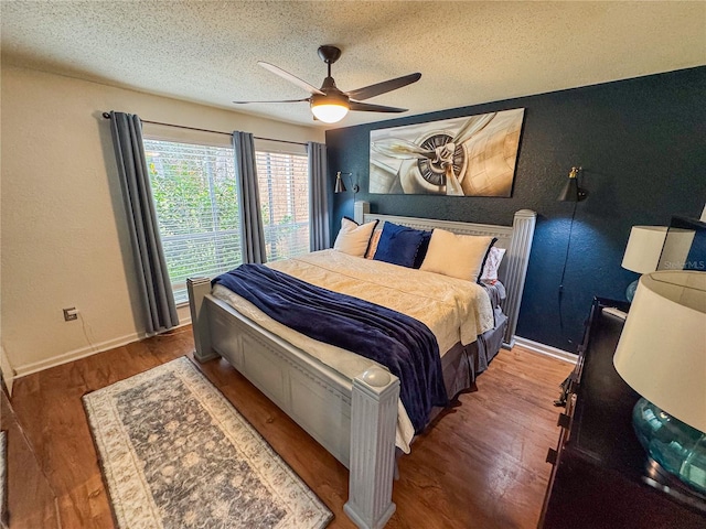 bedroom with hardwood / wood-style floors, a textured ceiling, and ceiling fan