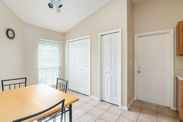 dining room featuring vaulted ceiling and light tile patterned floors