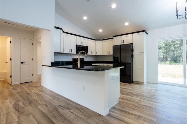 kitchen featuring light wood-type flooring, black fridge with ice dispenser, vaulted ceiling, kitchen peninsula, and white cabinetry