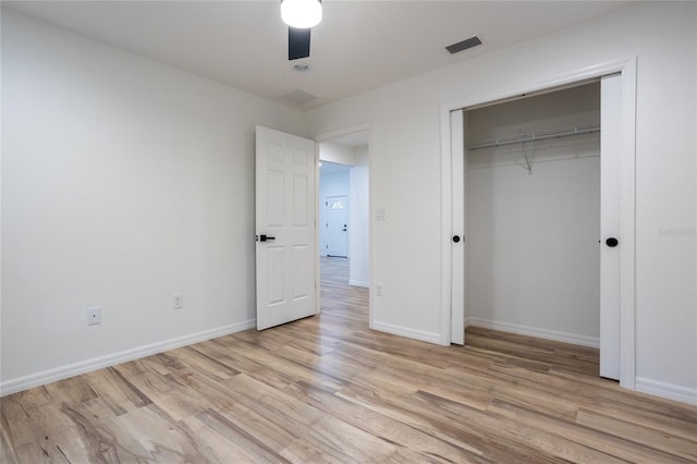 unfurnished bedroom with ceiling fan, light hardwood / wood-style flooring, and a closet