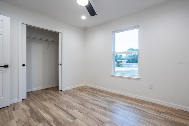 unfurnished bedroom featuring ceiling fan, light hardwood / wood-style flooring, and a closet