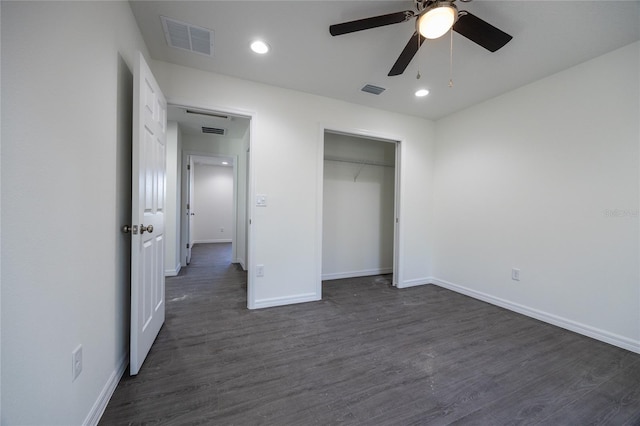 unfurnished bedroom with visible vents, dark wood finished floors, and baseboards