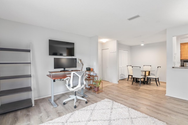 home office featuring visible vents, light wood-type flooring, and baseboards
