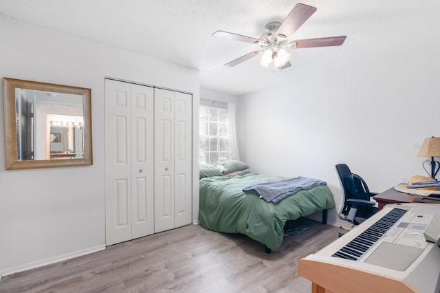 bedroom featuring ceiling fan, a textured ceiling, a closet, and light hardwood / wood-style floors