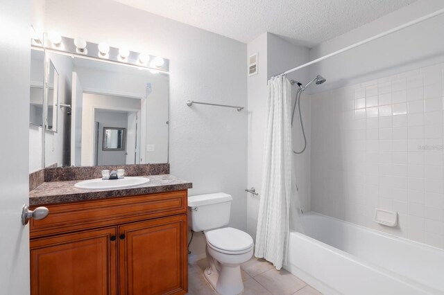 full bathroom with tile patterned flooring, toilet, vanity, visible vents, and a textured ceiling