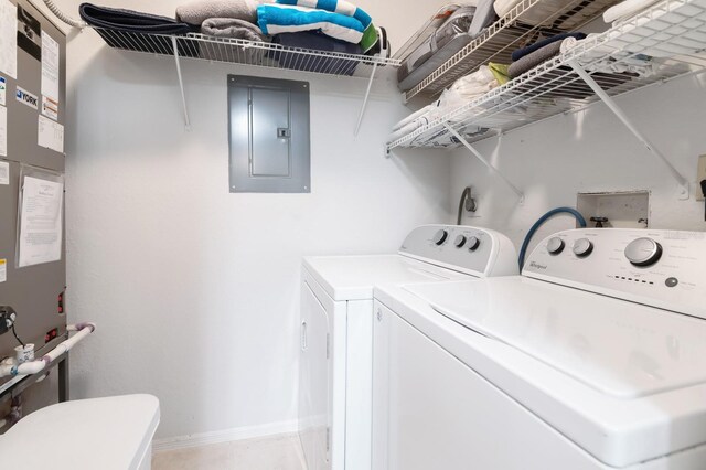 clothes washing area with baseboards, electric panel, laundry area, and independent washer and dryer