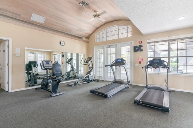 exercise room with baseboards, visible vents, ceiling fan, and lofted ceiling